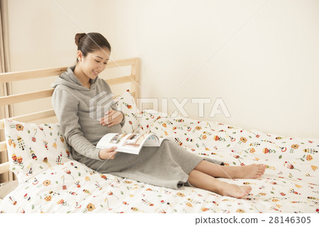 A woman relaxing in bed A woman relaxing in bed 28146305