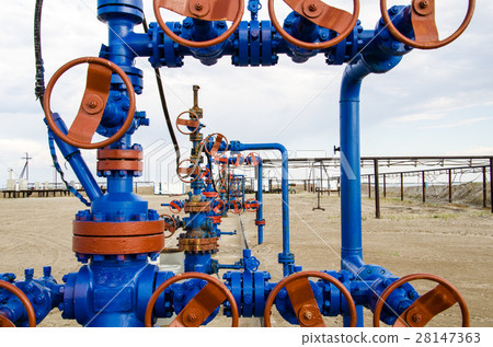 Group of wellheads. Oilfield with sand ground. Group of wellheads. Oilfield with sand ground. 28147363