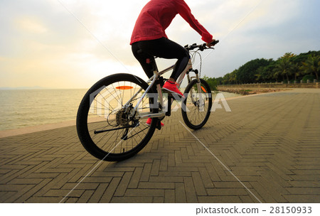 young woman riding bike on seaside 28150933