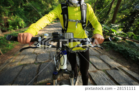 young woman riding mountain bike on forest trail 28151111