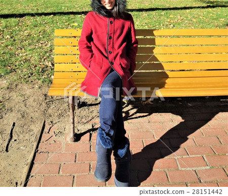 A woman sitting on a bench A woman sitting on a bench 28151442