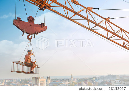 Man resting on construction on high and eating. 28152037
