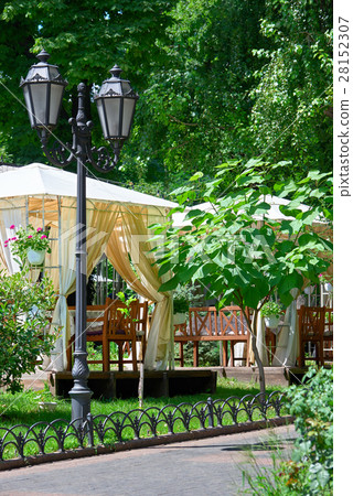 street cafe interior in city park, green trees 28152307