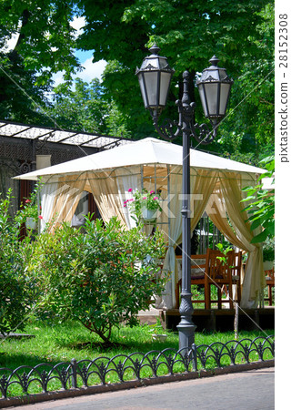 street cafe interior in city park, green trees 28152308