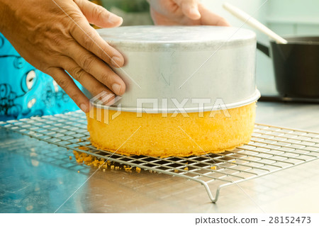 Cook taking out layer cake from cake form Cook taking out layer cake from cake form 28152473