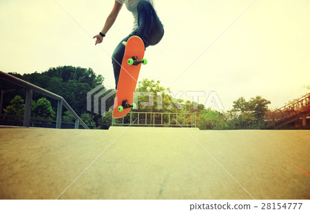 skateboarder legs doing a ollie trick at skatepark 28154777