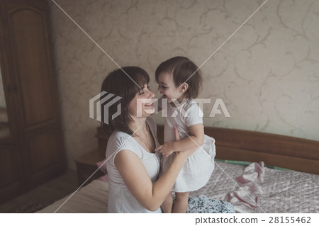Mother hugging playing with  daughter  lifestyle 28155462