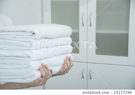 Housewife hand carrying a folded towel 28157296