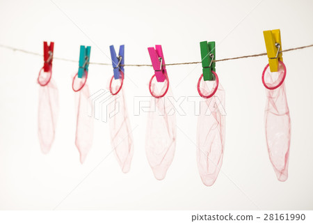 Unrolled latex condoms on white background 28161990