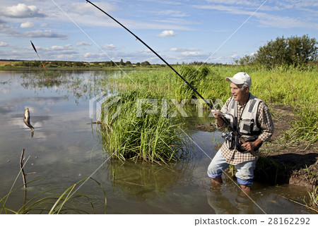 fisherman fishing on a river bank 28162292