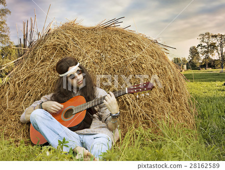 Hippie man playing guitar outdoors Hippie man playing guitar outdoors 28162589