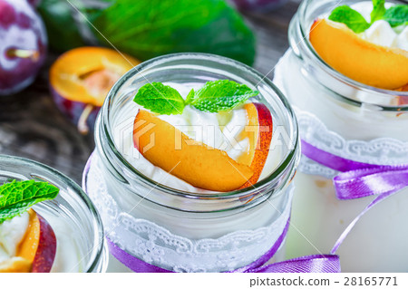 yogurt with ripe plums and mint in a glass jars 28165771