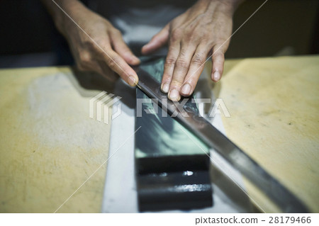 Craftsmen sharpening knives 28179466