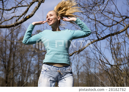 happy young woman in bright clothes jumps in sprin happy young woman in bright clothes jumps in sprin 28182782