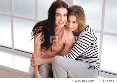 Cute emotional couple sitting on a window sill 28183463