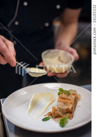 Decorating strudel with cream and mint, closeup Decorating strudel with cream and mint, closeup 28185332