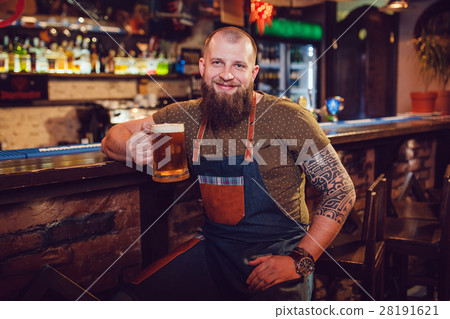Bearded barman with tattoos wearing an apron Bearded barman with tattoos wearing an apron 28191621