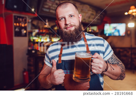 Bearded barman with tattoos wearing an apron 28191668