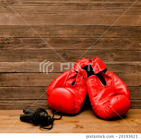 Two red boxing gloves lie on a wooden background 28193621