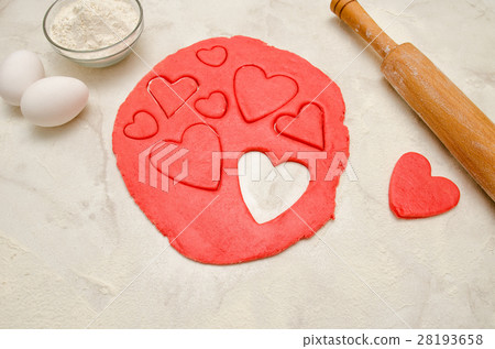 Red dough with a rolling pin and cut out hearts Red dough with a rolling pin and cut out hearts 28193658