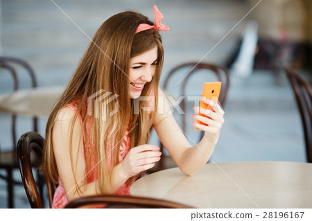 girl smiling and looking at mobile phone 28196167