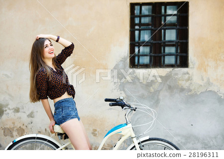Pretty girl is sitting on the bicycle have fun on 28196311