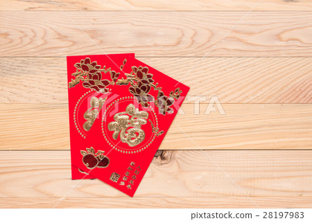 Chinese Red Envelope use in Chinese new year festival on wooden background. Translation in English meaning lucky and richly Chinese Red Envelope use in Chinese new year festival on wooden background. Translation in English meaning lucky and richly 28197983