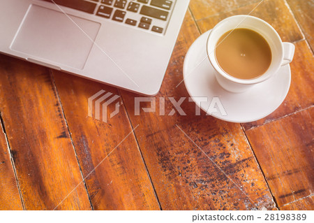 White coffee cup and laptop on wooden table top view White coffee cup and laptop on wooden table top view 28198389