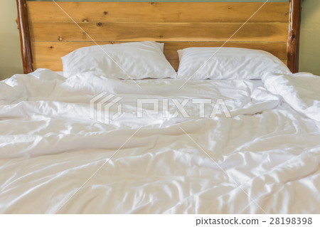 White bedding sheets and pillow on wooden wall room background, Messy bed concept White bedding sheets and pillow on wooden wall room background, Messy bed concept 28198398