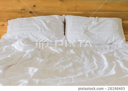White bedding sheets and pillow on wooden wall room background, Messy bed concept White bedding sheets and pillow on wooden wall room background, Messy bed concept 28198403