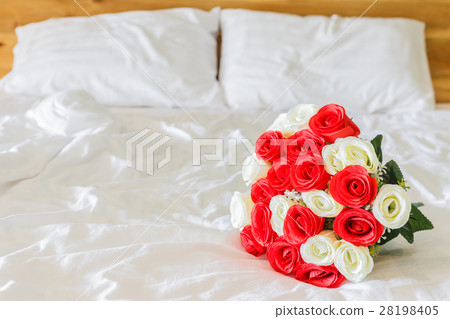 Bouquet on the white bed in hotel room Bouquet on the white bed in hotel room 28198405