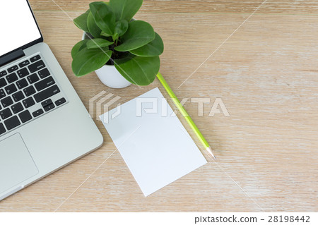 Laptop with blank white paper on wooden desk 28198442