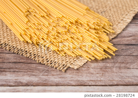 Yellow long spaghetti, Raw spaghetti on wooden Yellow long spaghetti, Raw spaghetti on wooden 28198724