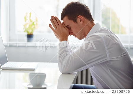 Man in a polo shirt stands leaning on railing 28208796