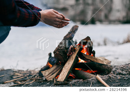 Girl warms hands near a fire in winter 28214396