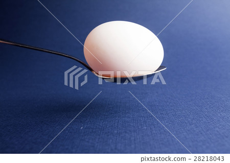 An egg on spoon isolated on blue background 28218043