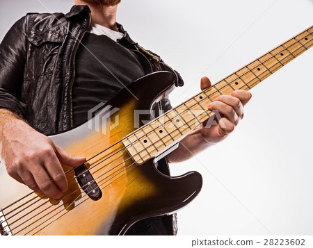 Bassist plays bass guitar. 28223602