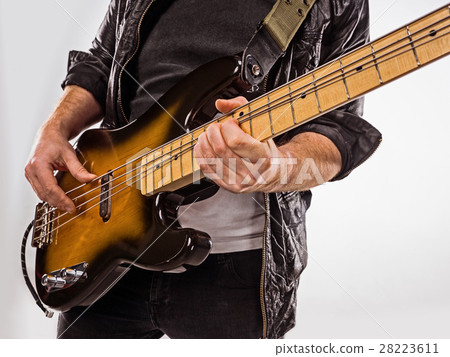 Bassist plays bass guitar. 28223611