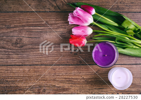 Pink Tulip Flowers and two cendels on rustic table 28227530