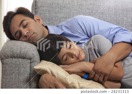 Father and son napping on sofa 28231313