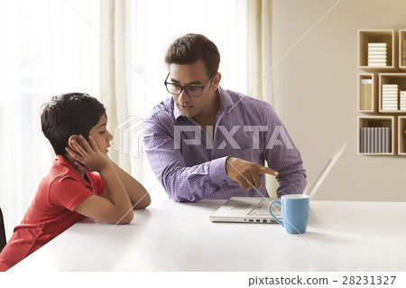 Father teaching to son using laptop at home 28231327