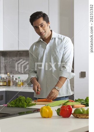Man cutting carrot in domestic kitchen Man cutting carrot in domestic kitchen 28231382