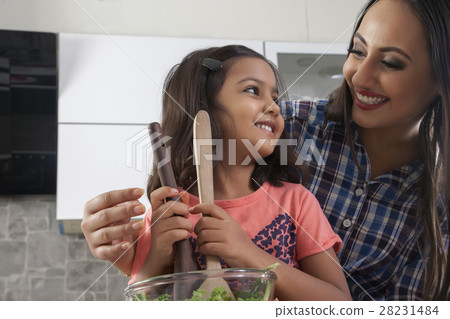 Mother and daughter preparing fresh salad in kitchen 28231484