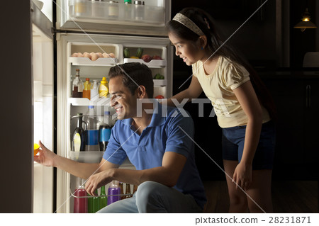 Father and daughter keeping food in refrigerator at night Father and daughter keeping food in refrigerator at night 28231871