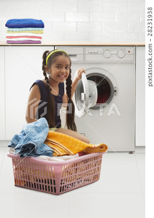 Young girl loading the washing machine Young girl loading the washing machine 28231938
