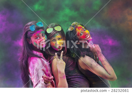 Portrait Of Three Young Indian Women With Colored Face Dancing During Holi Color festival 28232081