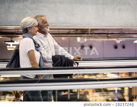 Senior couple traveling airport travelator scene Senior couple traveling airport travelator scene 28237248
