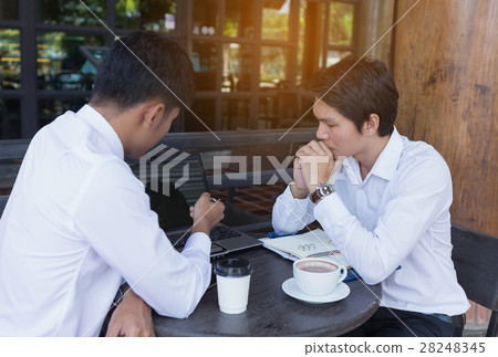 Businessman giving contract for signing to his partner Businessman giving contract for signing to his partner 28248345