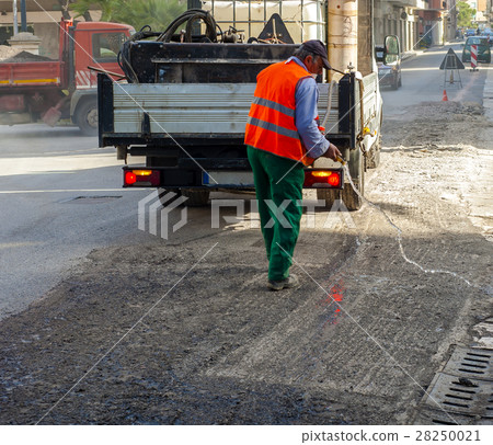 worker pours water on the milled asphalt worker pours water on the milled asphalt 28250021