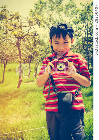 Happy asian boy relaxing outdoors in the day time Happy asian boy relaxing outdoors in the day time 28250407